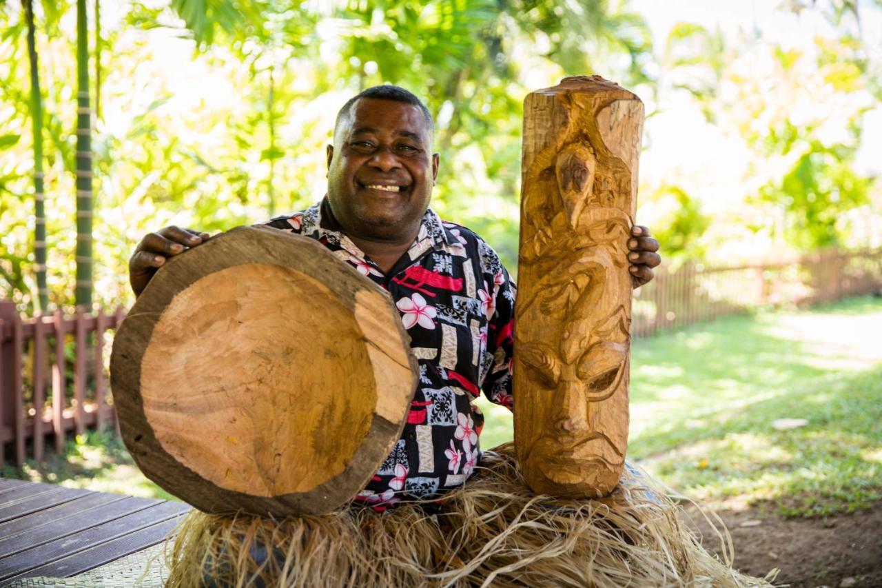 Outrigger Fiji Beach Resort Korotogo Exterior photo A man from the Solomon Islands with a drum and a carved post
